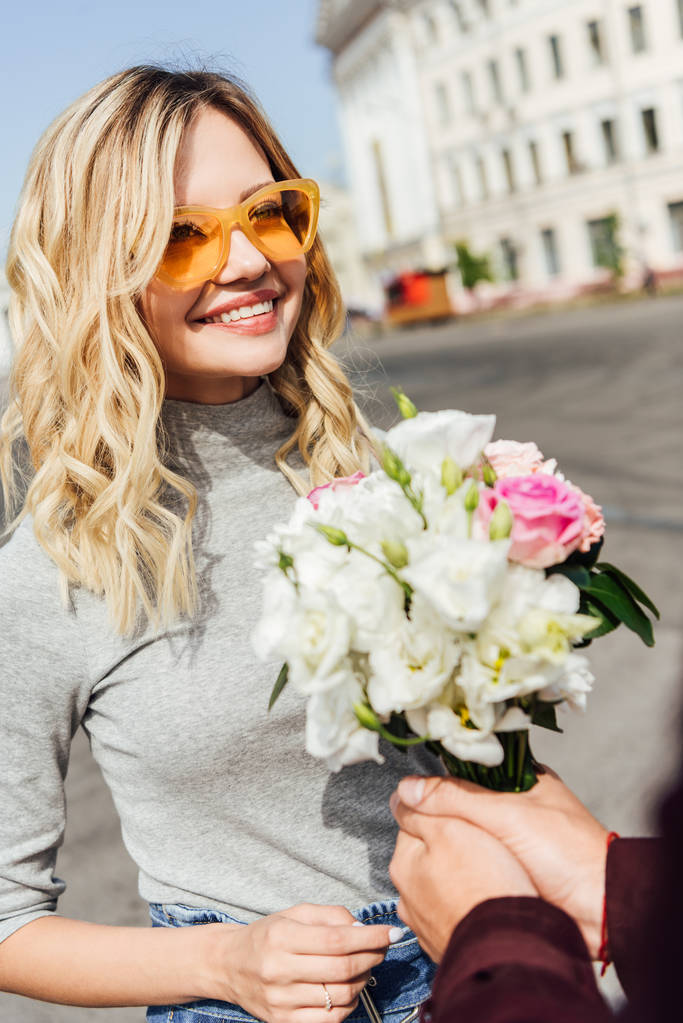 oříznutý obraz přítel prezentovat kytice atraktivní holku na ulici - Fotografie, Obrázek