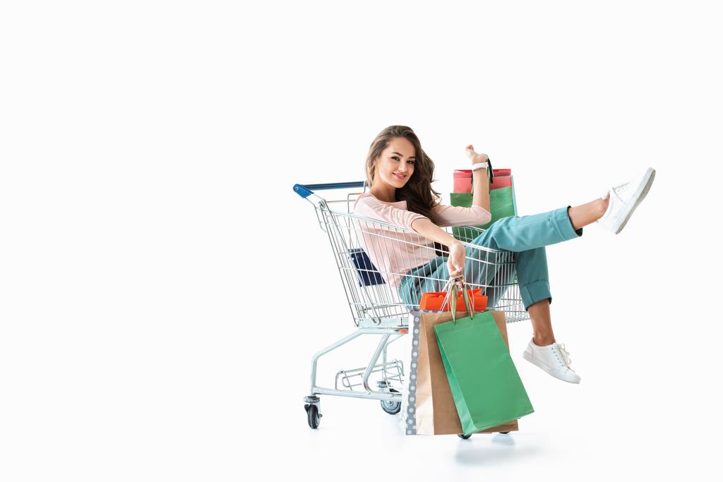 alışveriş sepeti ile çanta, üzerinde beyaz izole oturan mutlu güzel kız - Fotoğraf, Görsel