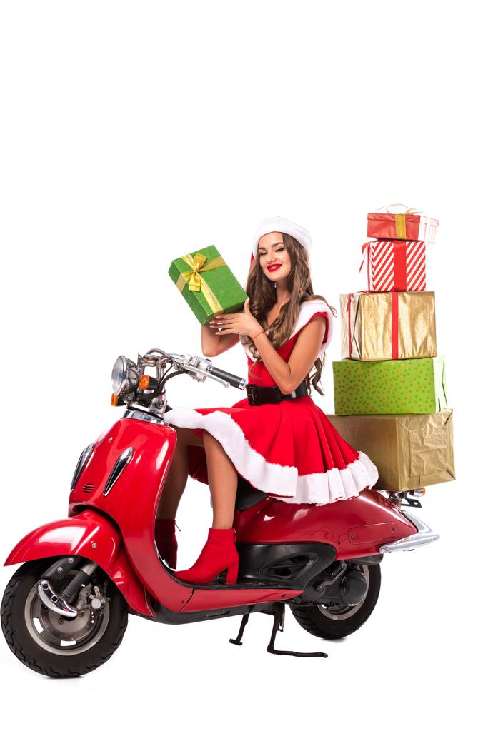 attractive girl in santa costume driving red scooter with gift boxes, isolated on white - Photo, Image