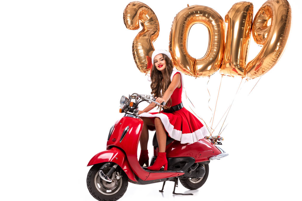 幸せな女の子サンタの衣装の 2019 年黄金の風船、白で隔離を赤いスクーターを運転 - 写真・画像