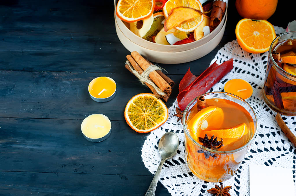 Dois copos com chá de laranja picante aromático, batatas fritas de frutas secas varietty e rolos de couro de frutas na caixa na mesa escura. Espaço de cópia
. - Foto, Imagem