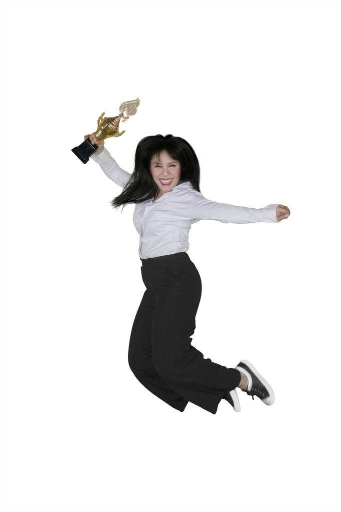 Успішна бізнес-леді стрибає в студії, тримаючи трофей, ізольований на білому тлі
 - Фото, зображення