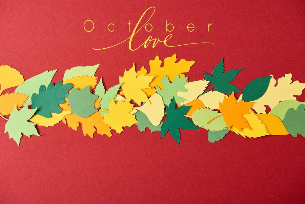 flat lay with colorful papercrafted leaves with "october love" lettering on red background - Photo, Image