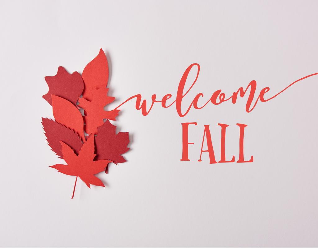 top view of red papercrafted leaves with "welcome fall" lettering on white background - Photo, Image