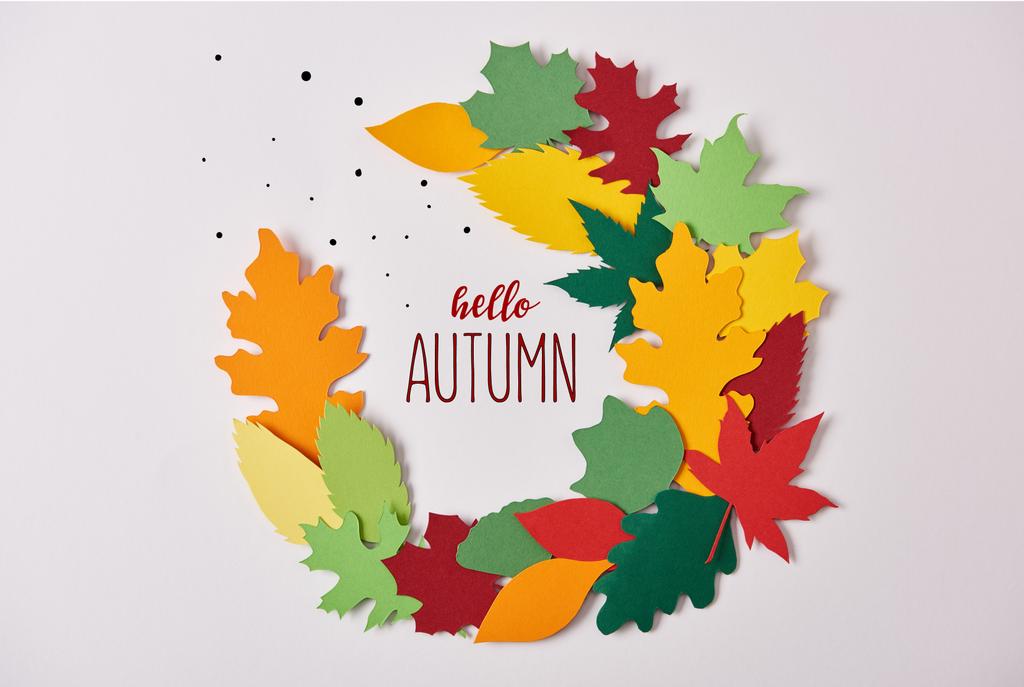 tendido plano con colorido follaje hecho en papel con letras de "hola otoño" sobre fondo blanco
 - Foto, imagen