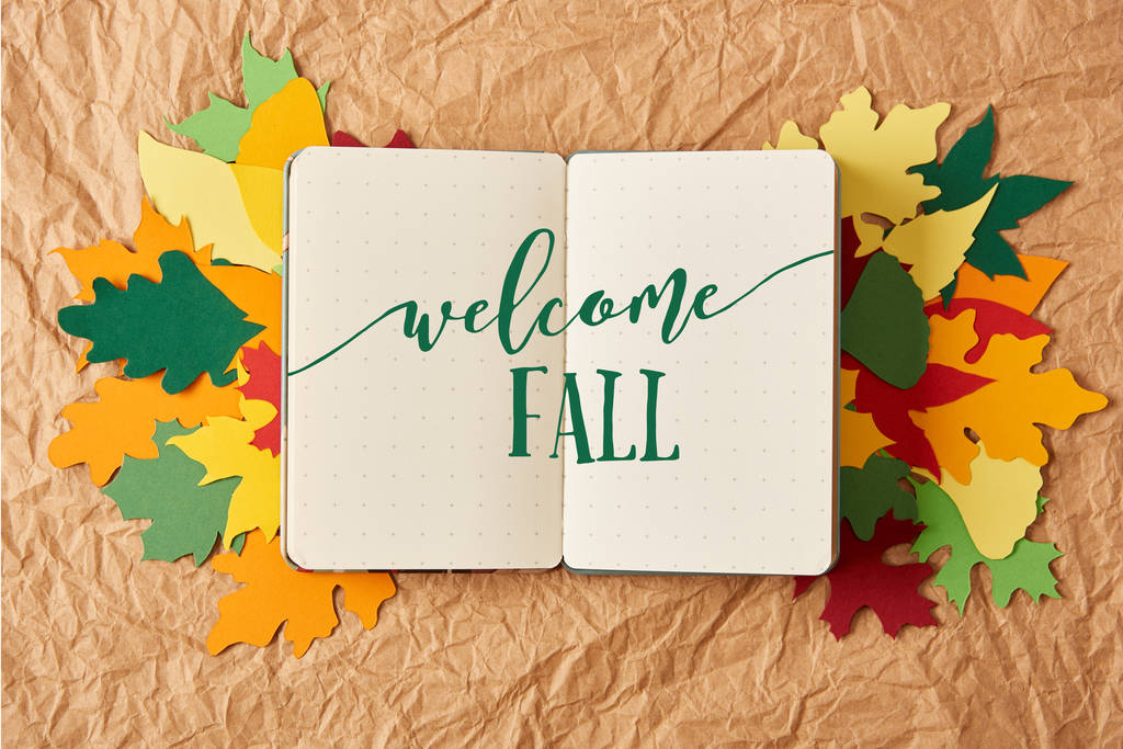 vue du haut du carnet avec lettrage "bienvenue automne" sur des feuilles de papier colorées faites à la main sur fond de papier froissé
 - Photo, image