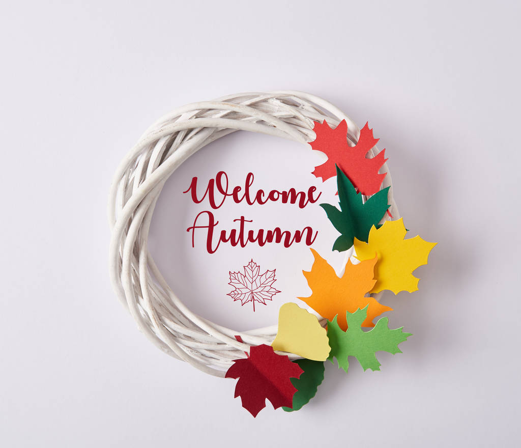 pohled shora ruční věnec s barevné papírové listy a nápis "Vítejte na podzim" na bílém pozadí - Fotografie, Obrázek