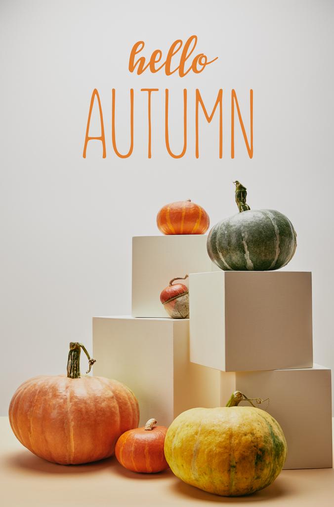 autumnal decoration with orange, yellow and green pumpkins on cubes and table with HELLO AUTUMN lettering - Photo, Image
