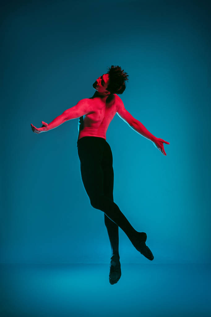 Mužské atletické baletní tanečník provedením tanec na modrém pozadí. Studio záběr. Koncepce baletu. Přizpůsobit mladý muž. Kavkazská model - Fotografie, Obrázek