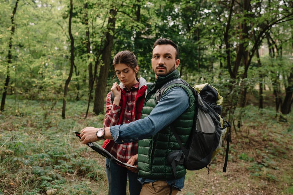 couple of travelers with map got lost in woods - Photo, Image