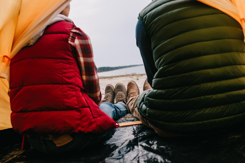 takaisin näkymä pari istuu camping teltta hiekkarannalla
 - Valokuva, kuva