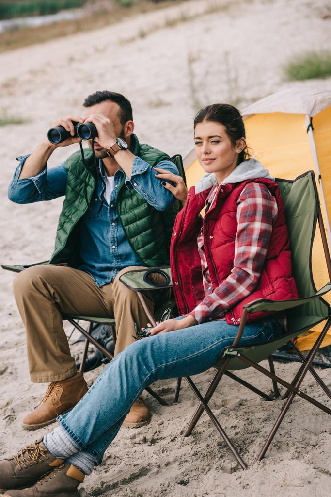 couple avec jumelles reposant sur des chaises sur le camping
 - Photo, image