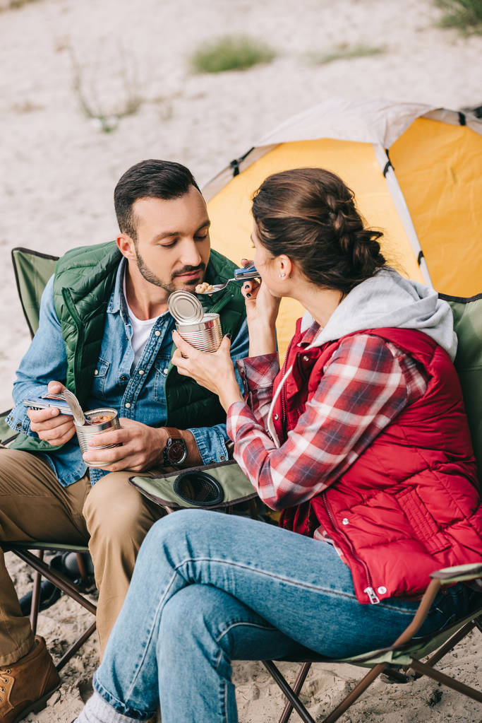 Kobieta, karmienie mąż mając ze sobą camping - Zdjęcie, obraz