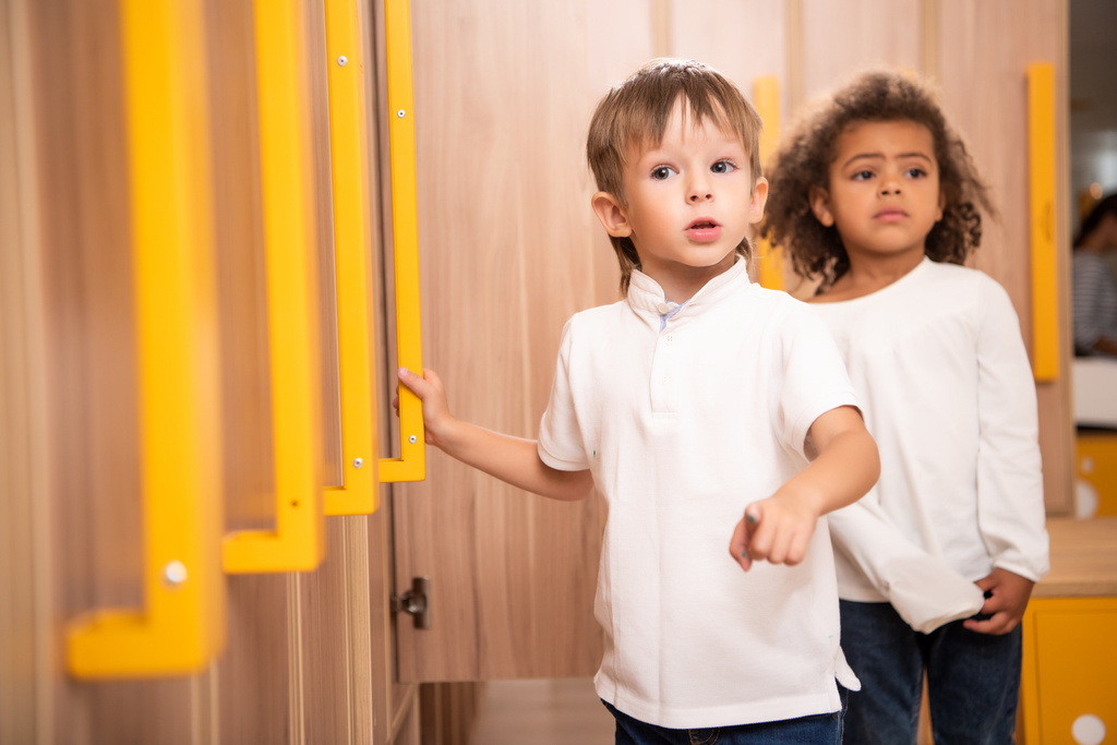 multi-etnisch kinderen permanent in kleuterschool garderobe - Foto, afbeelding