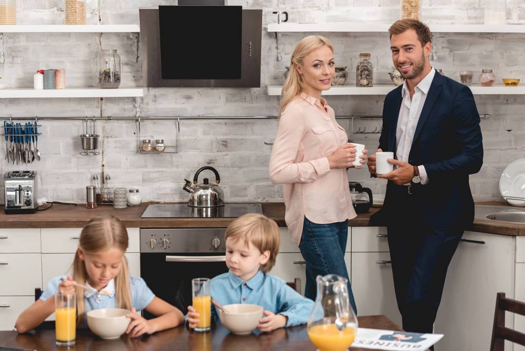 ungezwungene junge Familie beim gemeinsamen Frühstück in der Küche - Foto, Bild