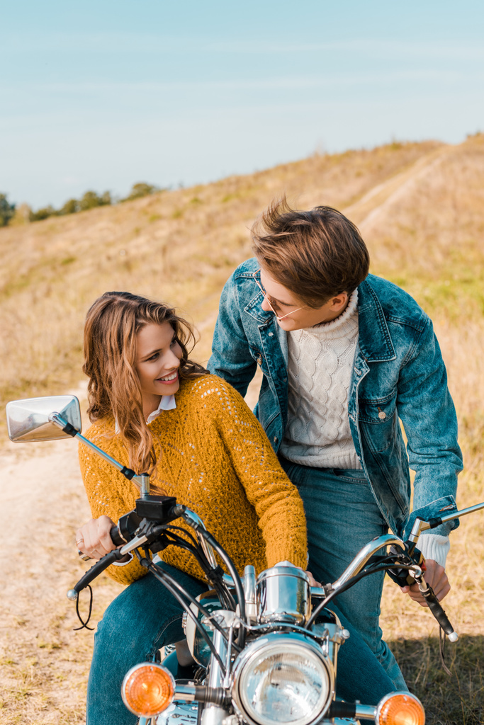 joven pareja sentado en moto y sonriendo el uno al otro
 - Foto, Imagen