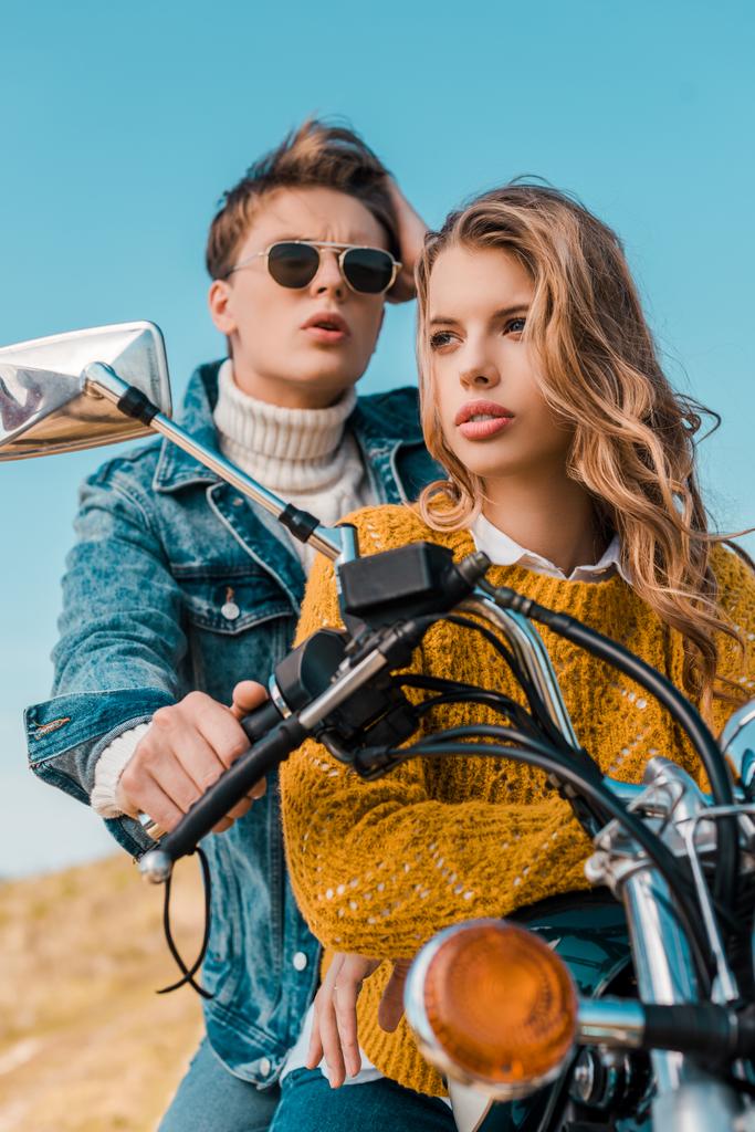 mavi gökyüzü karşı motosiklet üzerinde oturan genç çift  - Fotoğraf, Görsel