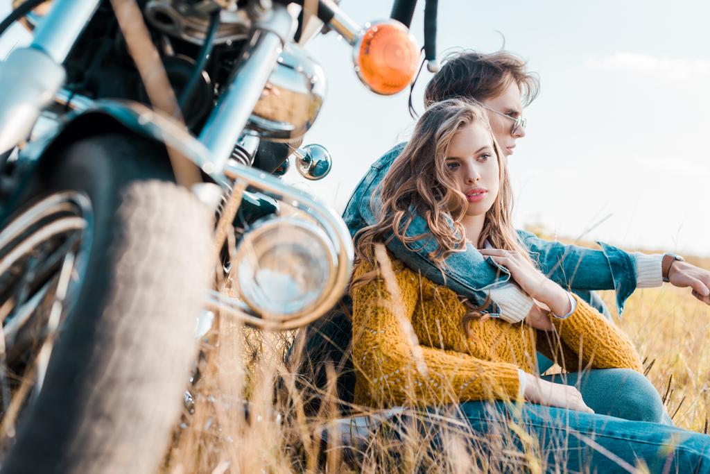 poikaystävä halaus tyttöystävä ja istuu lähellä vintage moottoripyörä
 - Valokuva, kuva