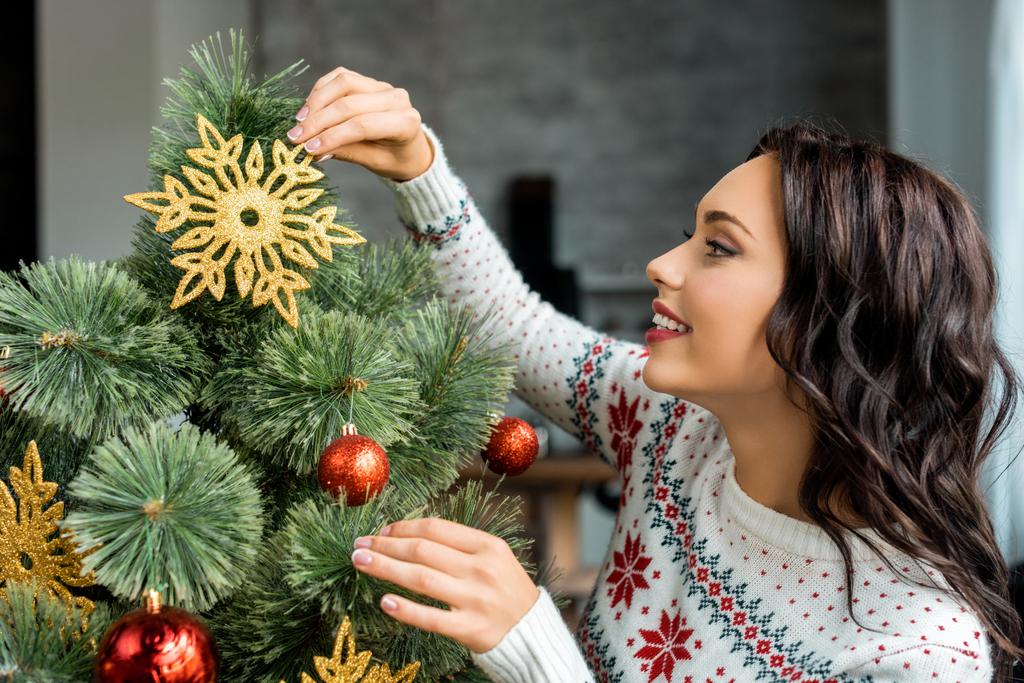 vista lateral de mujer atractiva decorando árbol de Navidad en casa
  - Foto, imagen