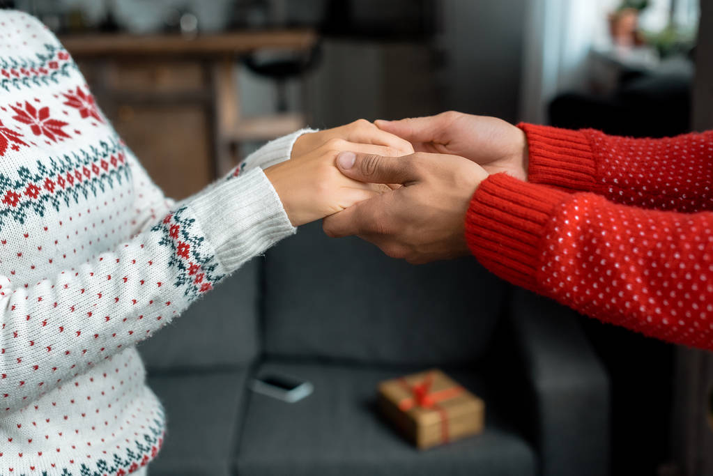 abgeschnittenes Bild eines Mannes, der Händchen hält und Freundin führt, um an Weihnachten zu Hause eine Überraschung zu machen  - Foto, Bild