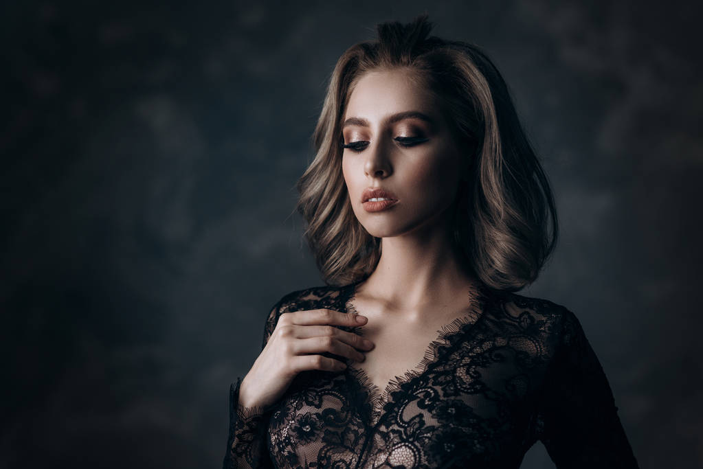 mooie sexy jonge blonde vrouw poseren in lingerie zwarte kant - Foto, afbeelding