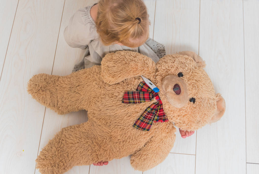 la fille, enfant mesure la température du corps de l'ours jouet, joue le médecin
 - Photo, image