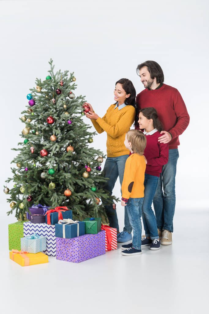 családi áll közel a karácsonyfa díszítő anya bemutatja a elszigetelt fehér - Fotó, kép