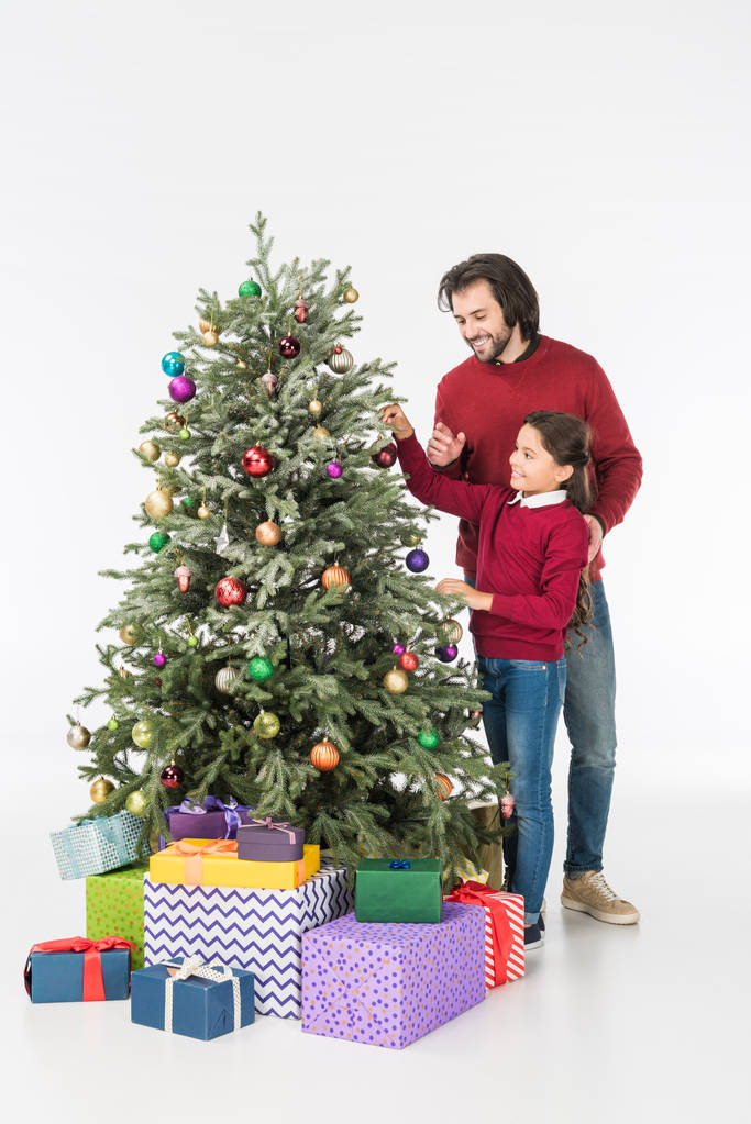χαμογελά πατέρα με κόρη διακόσμηση χριστουγεννιάτικο δέντρο με παρουσιάζει απομονωθεί σε λευκό - Φωτογραφία, εικόνα