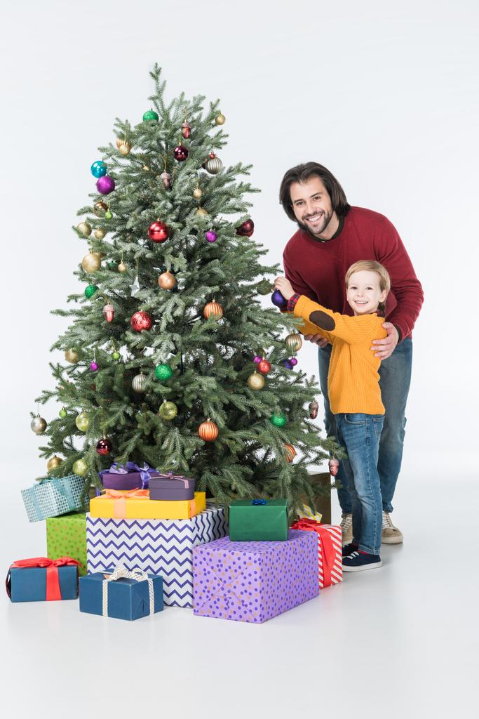 白で隔離プレゼントとクリスマス ツリーを飾ることの息子と父 - 写真・画像