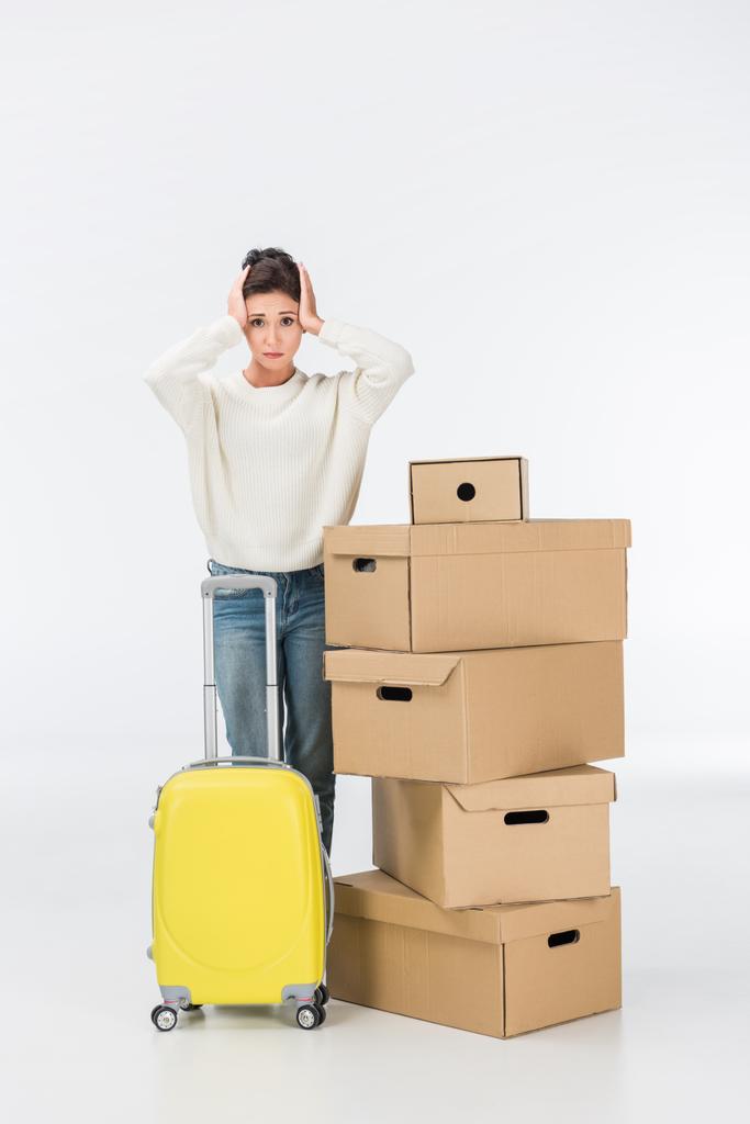 stressed woman with suitcase and cardboard boxes moving to new house isolated on white - Photo, Image