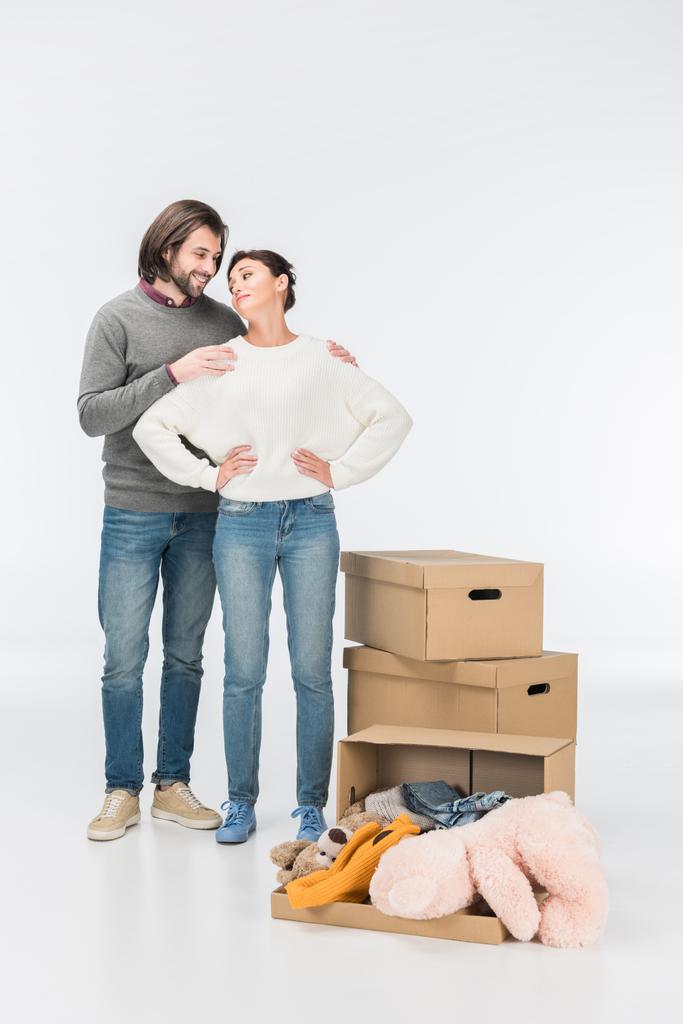 пара, стоящая рядом коробка с игрушками и глядя друг на друга изолированы на белом
  - Фото, изображение