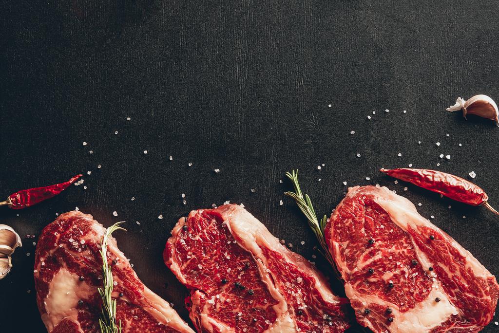çiğ et biftek ve baharat mutfak yüzey üzerinde yükseltilmiş görünümü - Fotoğraf, Görsel