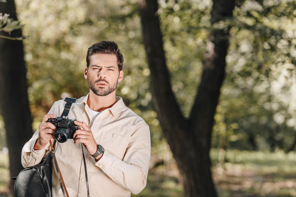 πορτρέτο του τουρίστας με φωτογραφική μηχανή φωτογραφιών σε χέρια στο πάρκο - Φωτογραφία, εικόνα