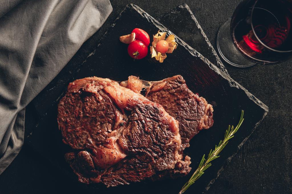 emelt szintű kilátás a sült steak vágódeszkák, üveg vörös bort a konyhában asztali - Fotó, kép