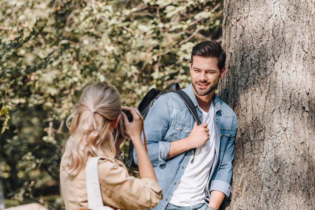 woman taking picture of stylish boyfriend in autumn park - Photo, Image