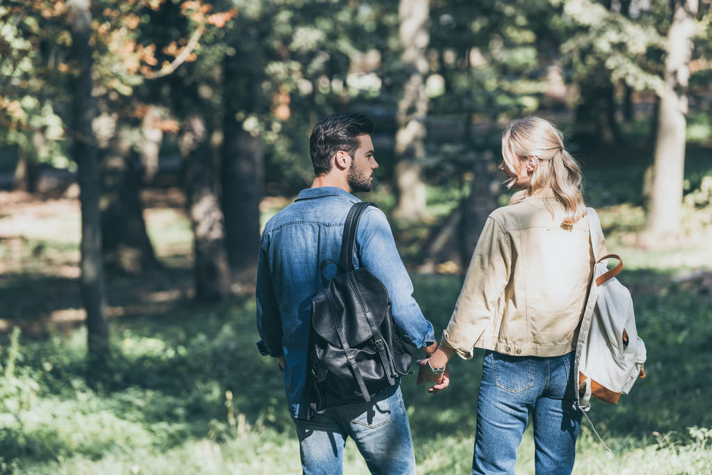Hátulnézet a fiatal pár, hátizsákok, őszi park séta - Fotó, kép