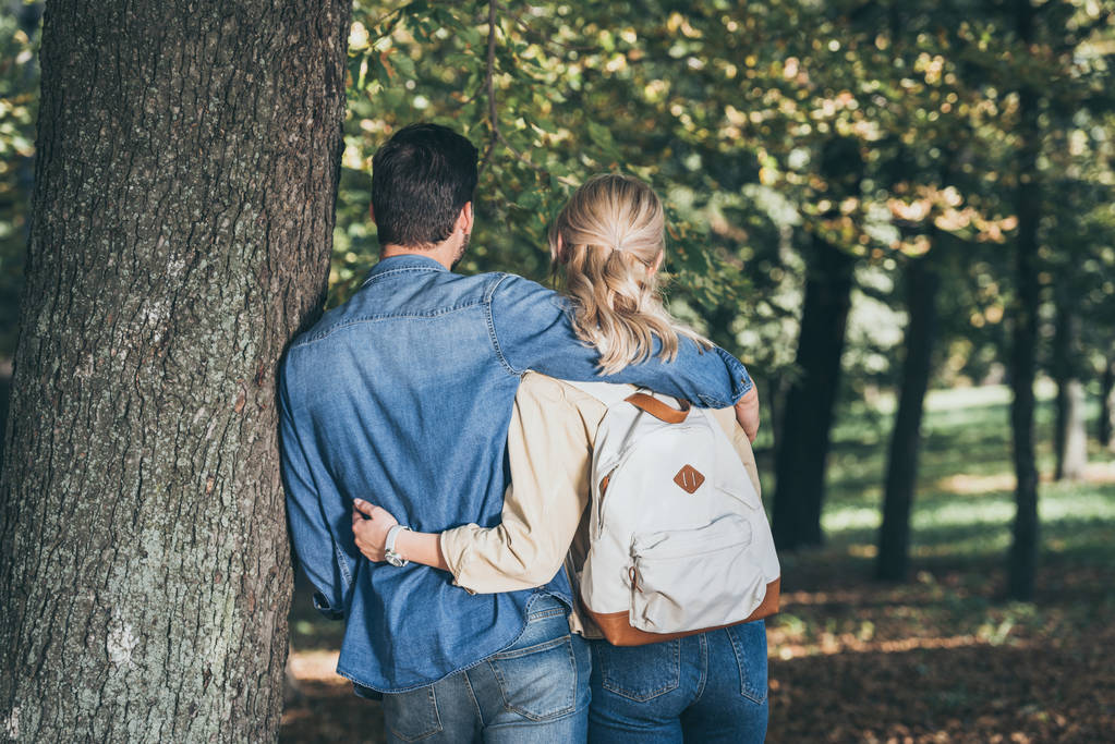 back view of stylish couple hugging near tree in park - Photo, Image
