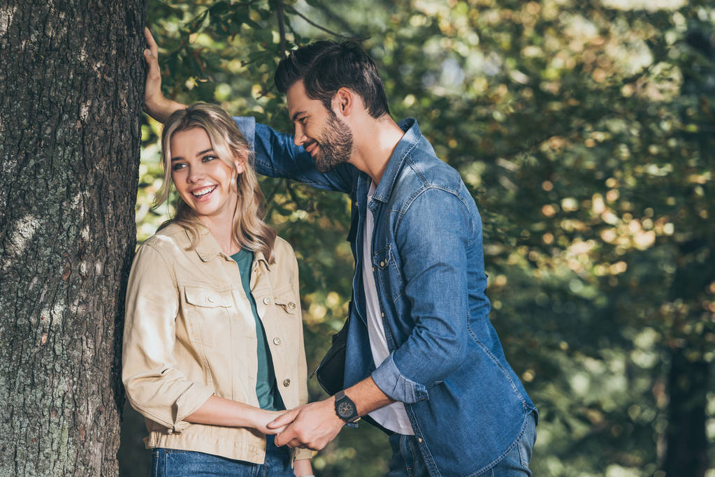 happy romantic couple holding hands in autumn park - Photo, Image