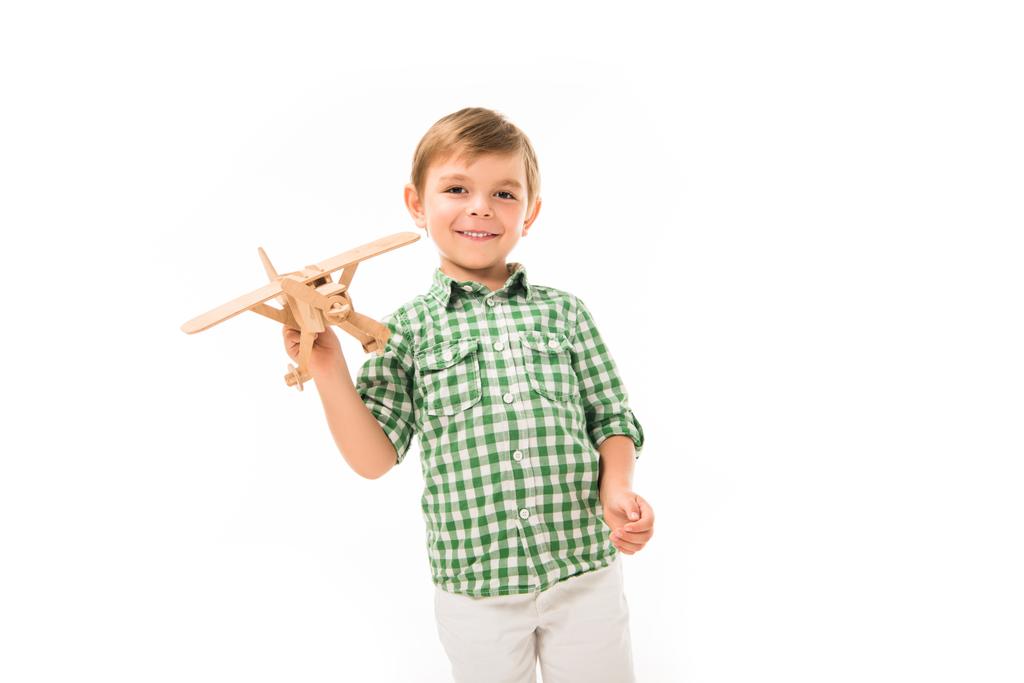 cheerful little boy playing with wooden toy plane isolated on white background - Photo, Image