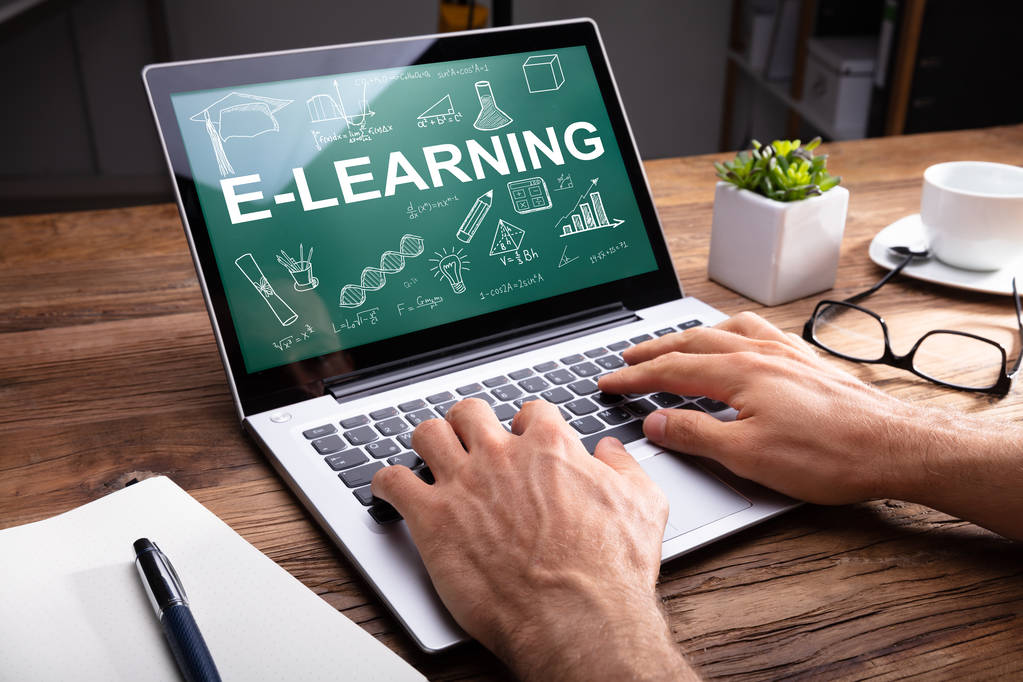 Mano dell'uomo utilizzando il computer portatile che mostra il concetto di E-learning sullo schermo
 - Foto, immagini