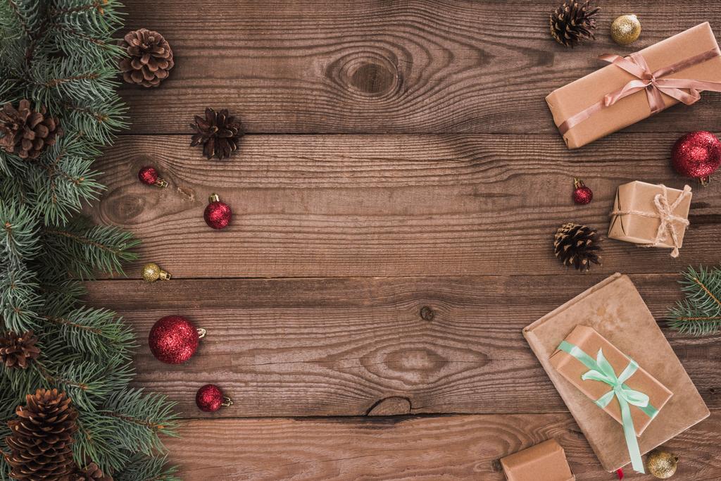 ylhäältä näkymä havupuiden oksat mänty käpyjä, helyjä ja joululahjat puinen tausta
 - Valokuva, kuva