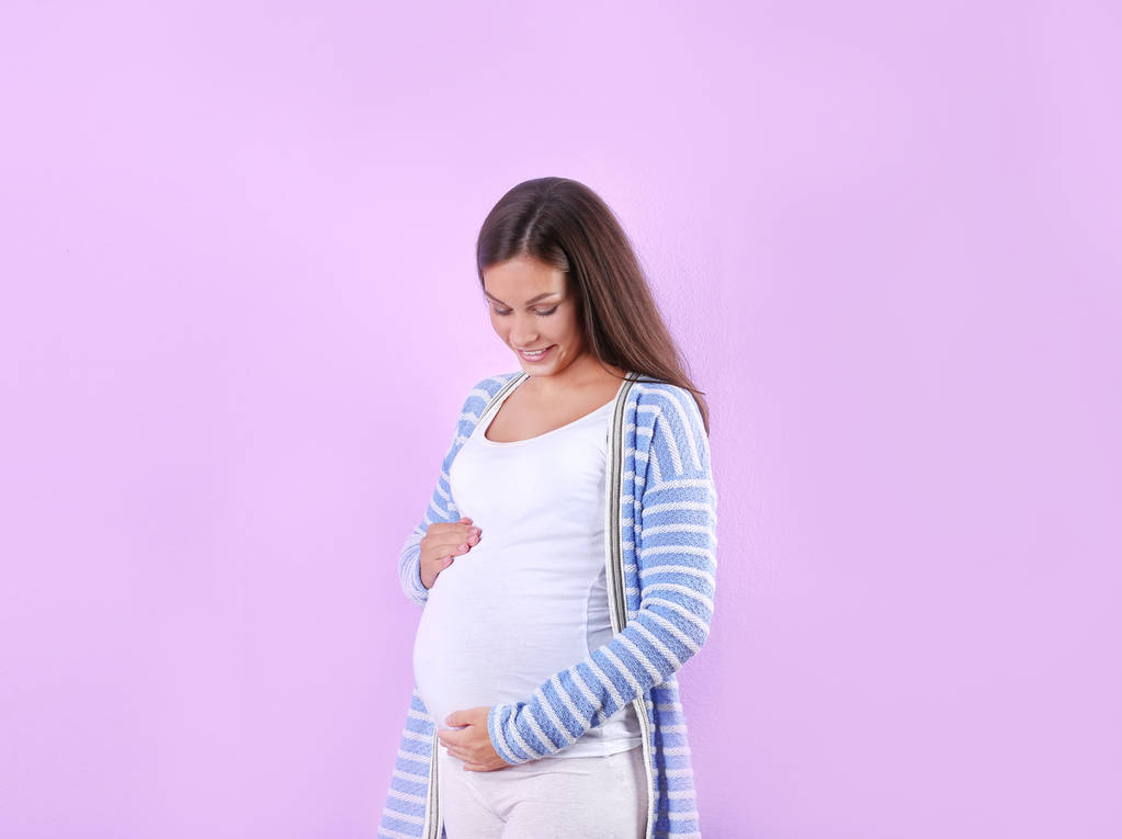 Szczęśliwy w ciąży kobieta pozowanie na białym tle - Zdjęcie, obraz