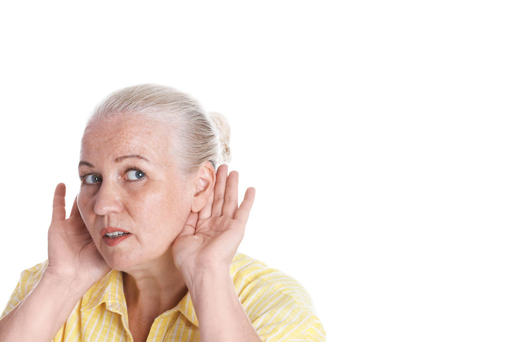 Mujer madura con problemas de audición sobre fondo blanco - Foto, imagen