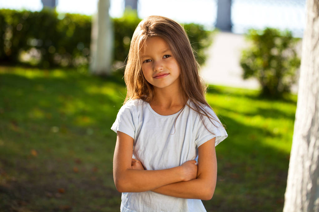 Portréja egy gyönyörű fiatal barna kis lány, nyáron a szabadban - Fotó, kép