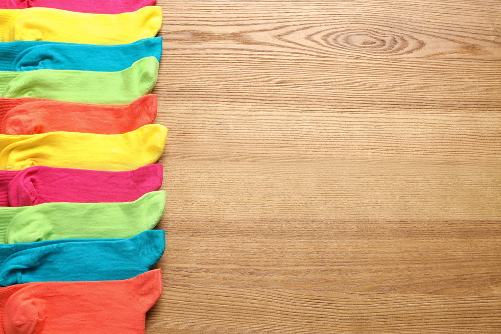 Composición plana con diferentes calcetines de colores y espacio para texto sobre fondo de madera
 - Foto, imagen