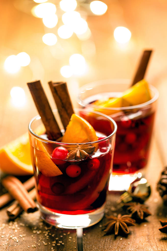 Boże Narodzenie grzane czerwone wino z przyprawami i pomarańcze na drewnianym stole rustykalny. Tradycyjne gorący napój na Boże Narodzenie - Zdjęcie, obraz
