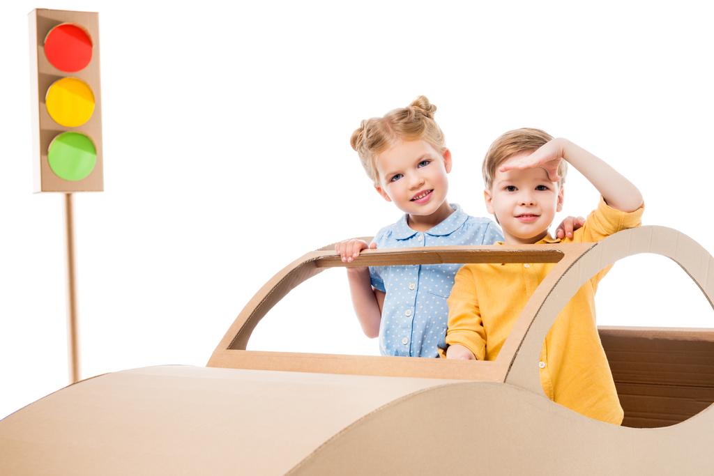 rodzeństwo, grając z tekturowym samochód i sygnalizacją świetlną, na białym tle  - Zdjęcie, obraz