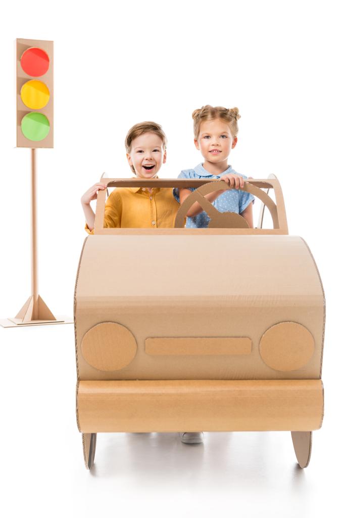 白地の背景に信号のあるダン ボールの車を運転して興奮してかわいい子供たち  - 写真・画像