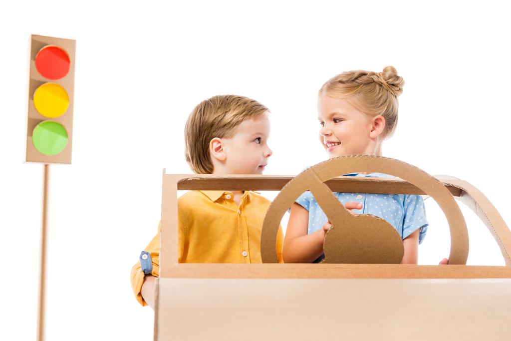 adorable children driving cardboard car with traffic lights on background, isolated on white  - Photo, Image