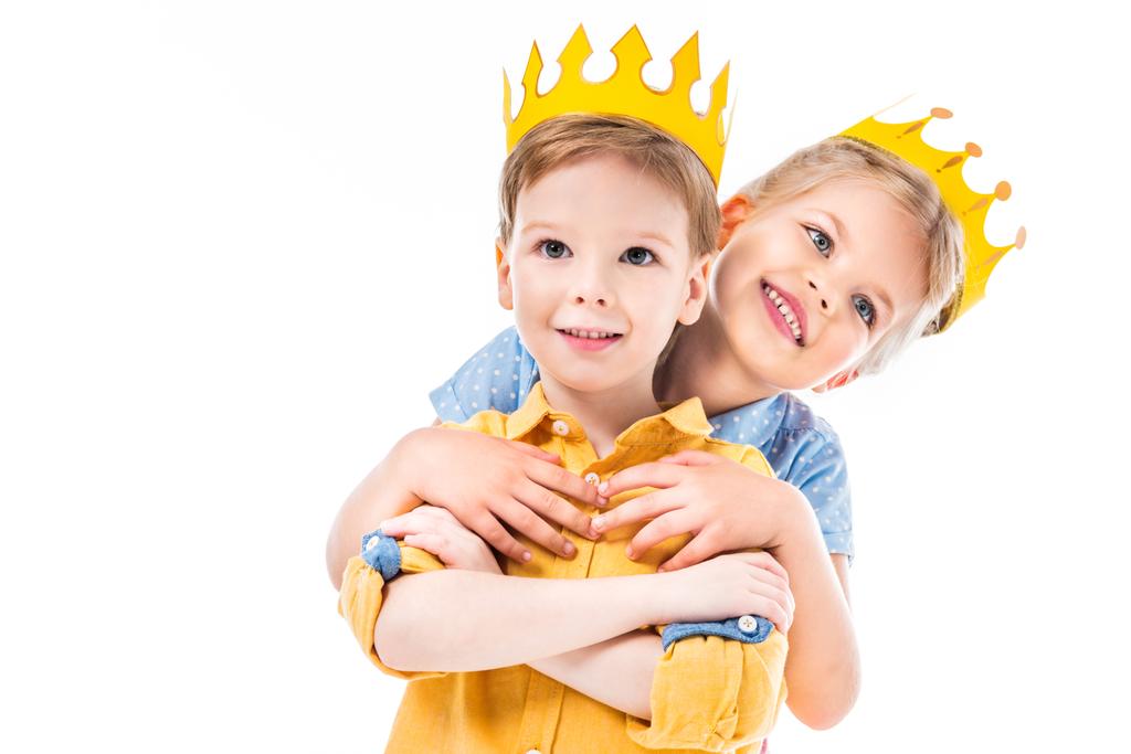 irmã abraçando irmão, crianças em coroas de papel amarelo, isolado em branco
  - Foto, Imagem
